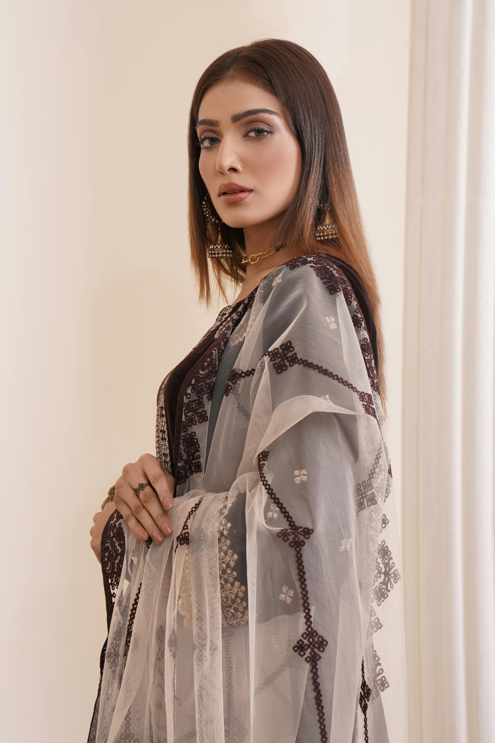 Stylish woman in embroidered dress showcasing elegance and beauty.